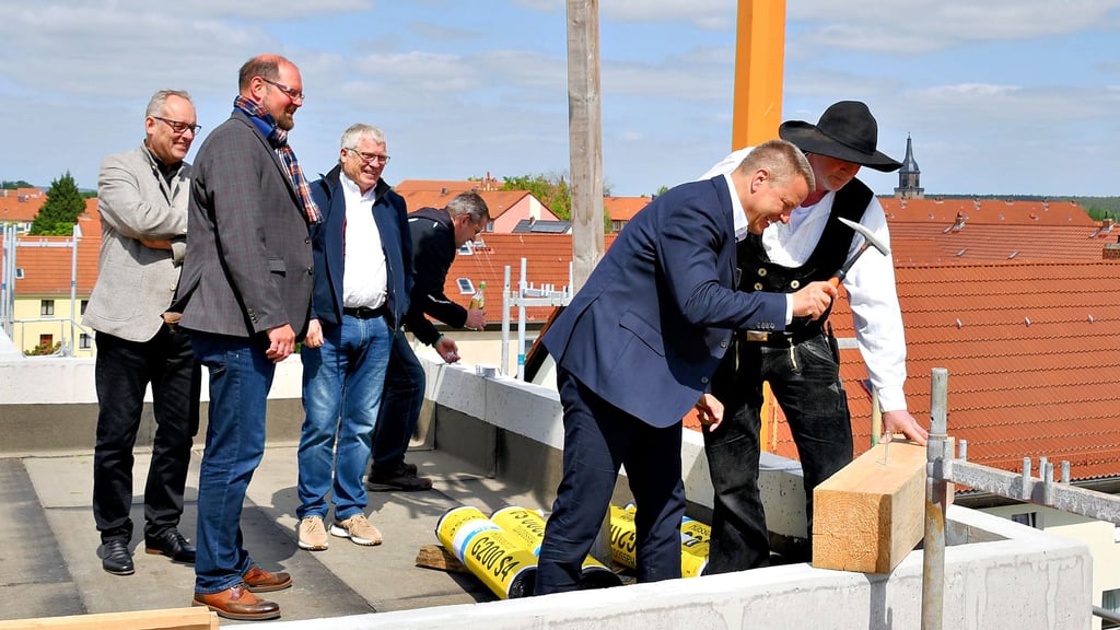Bauplaner Volker Seidl (v.l.), Landrat Martin Stichnoth und Wolfgang Kaiser von der WBG freuen sich, wie Bürgermeister Bernhard Hieber neben Zimmermann Michael Engler einen symbolischen Nagel einschlägt. Gleiches taten auch Wolfgang Kaiser und Martin Stichnoth.