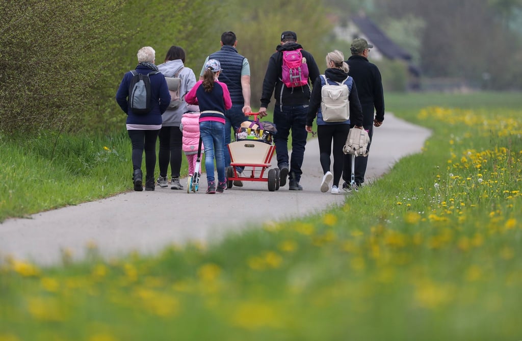 Menschen ziehen einen Bollerwagen.