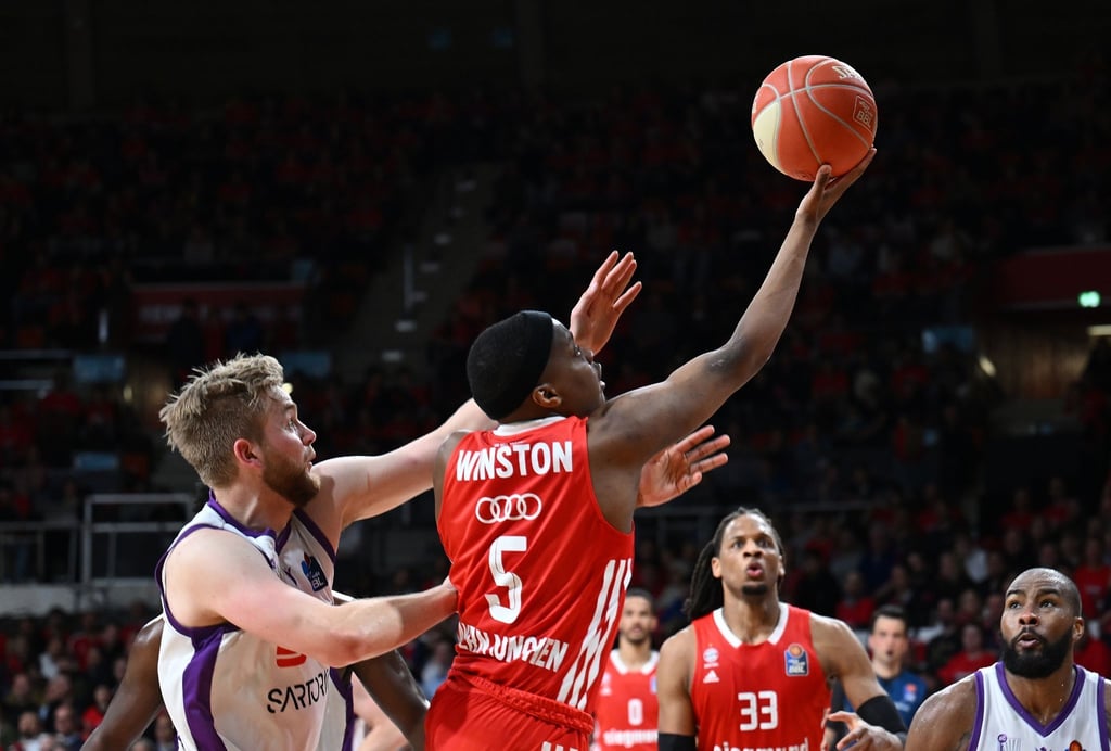 Bayerns Cassius Winston (M) und Göttingens Till Pape (l) in Aktion.