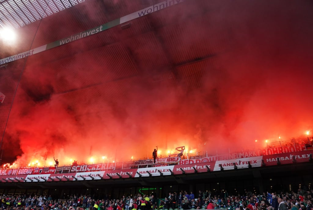 Bayern-Fans brennen auf der Tribüne Feuerwerkskörper ab.