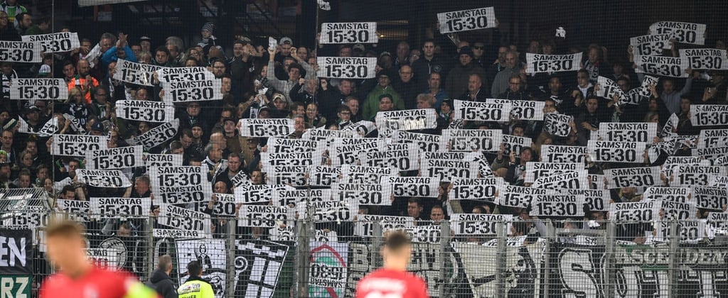 Fans von Wolfsburg protestieren mit Plakaten gegen die Zerstückelung der Spieltage.