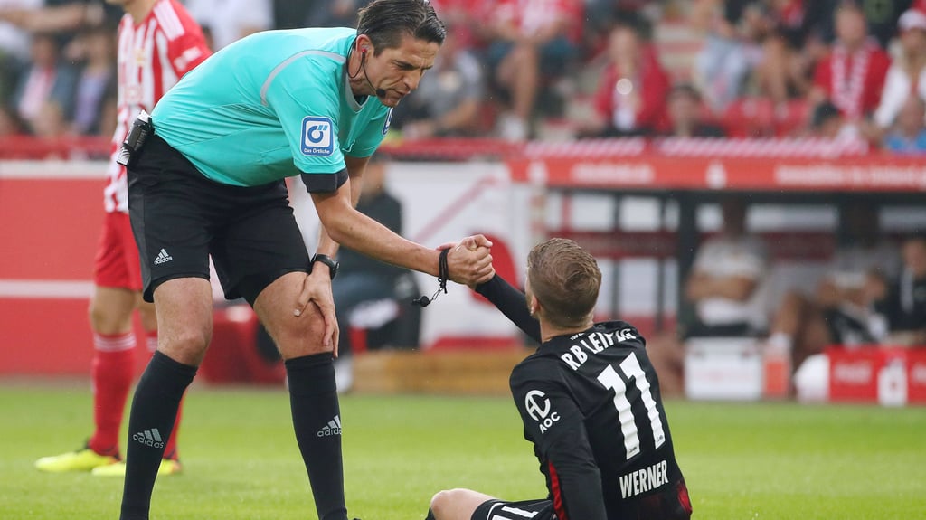 Schiedsrichter Deniz Aytekin hilft Timo Werner hoch.