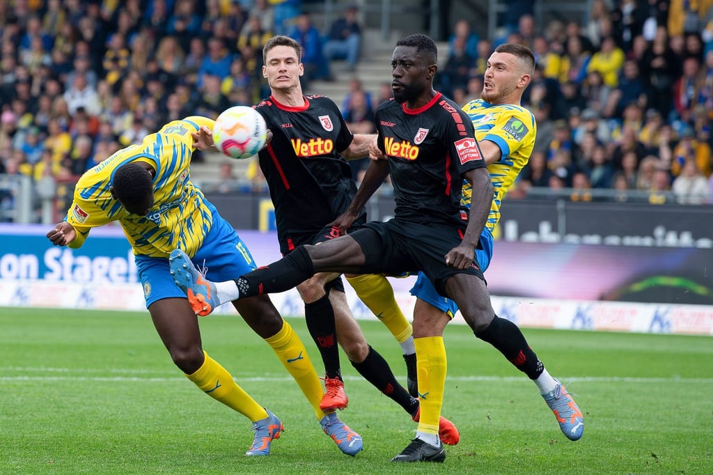 Braunschweigs Tarsis Bonga (l) köpft den Ball gegen Regensburgs Prince Osei Owusu auf das Tor.