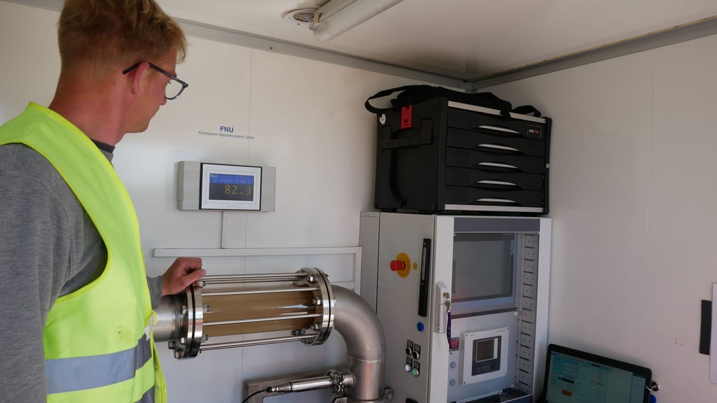 SWM-Mitarbeiter Florian Horenburg inspiziert die Überwachung der Daten, die den Reinigungsgrad der Rohrleitung anzeigen. Das getrübte Wasser wird ins Abwassernetz eingeleitet oder über Standrohre entsorgt. Die Rohrspülung ist beendet, wenn das Wasser wieder klar ist und vorgegebene Messdaten erreicht werden.