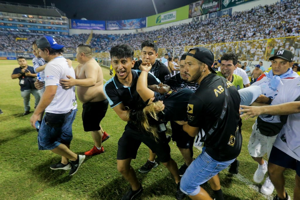 Ein verletzter Fan wird vom Spielfeld des Cuscatlan-Stadions in San Salvador, El Salvador, getragen.