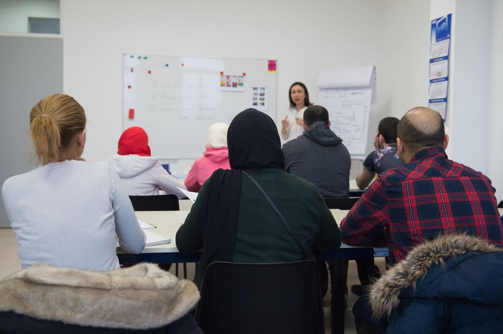 Flüchtlinge besuchen in einer Erstaufnahmeeinrichtung einen Erstorientierungskurs.