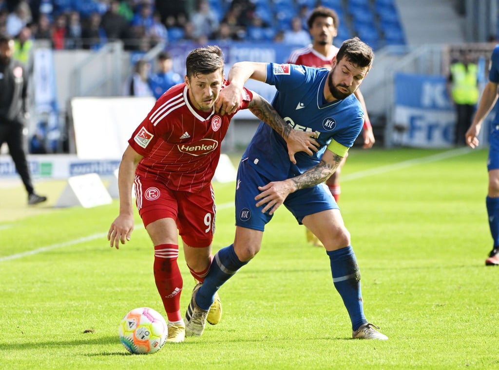 Der Karlsruher Jerome Gondorf (r) und der Düsseldorfer Dawid Kownacki kämpfen um den Ball.