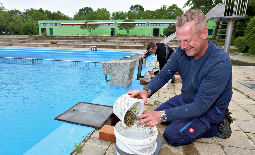 Schwimmmeister Steffen Schaaf (vorn) und Rettungsschwimmer Rick Schablinksi reinigen die Pumpenvorfilter.
