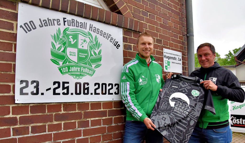 Sportvorstand Martin Rüssel (links) und Veranstaltungsvorstand Christian Hoffmann organisieren mit einem Festkomitee die Jubiläumsfeier zu „100 Jahren Fußball in Hasselfelde". Das Jubiläumstrikot, das sie zeigen, hat der Tourismusbetrieb gesponsert.
