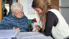 Eine Seniorin lässt sich beim Ausfüllen ihres Wohngeldantrages helfen.