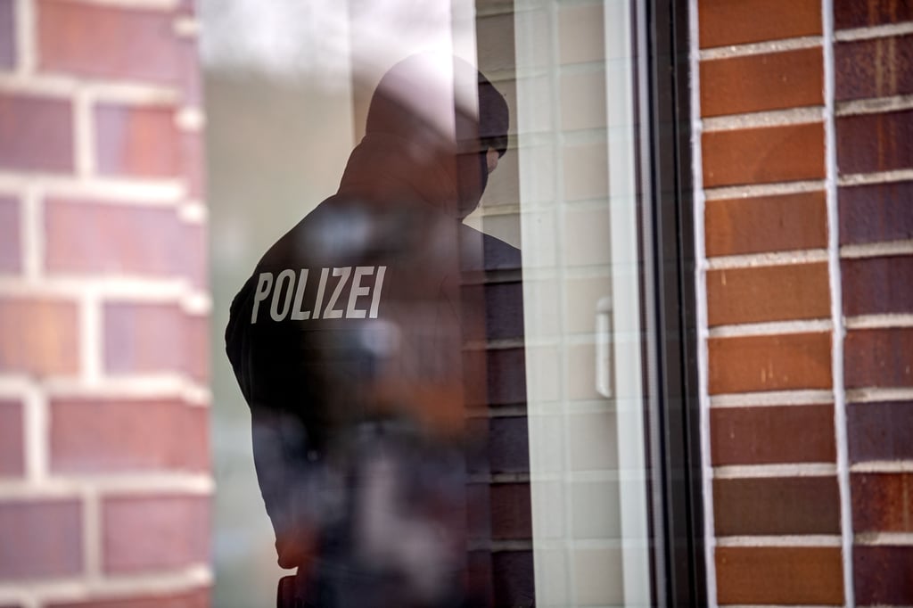 Ein Polizist bei einer Durchsuchung (Symbolbild)