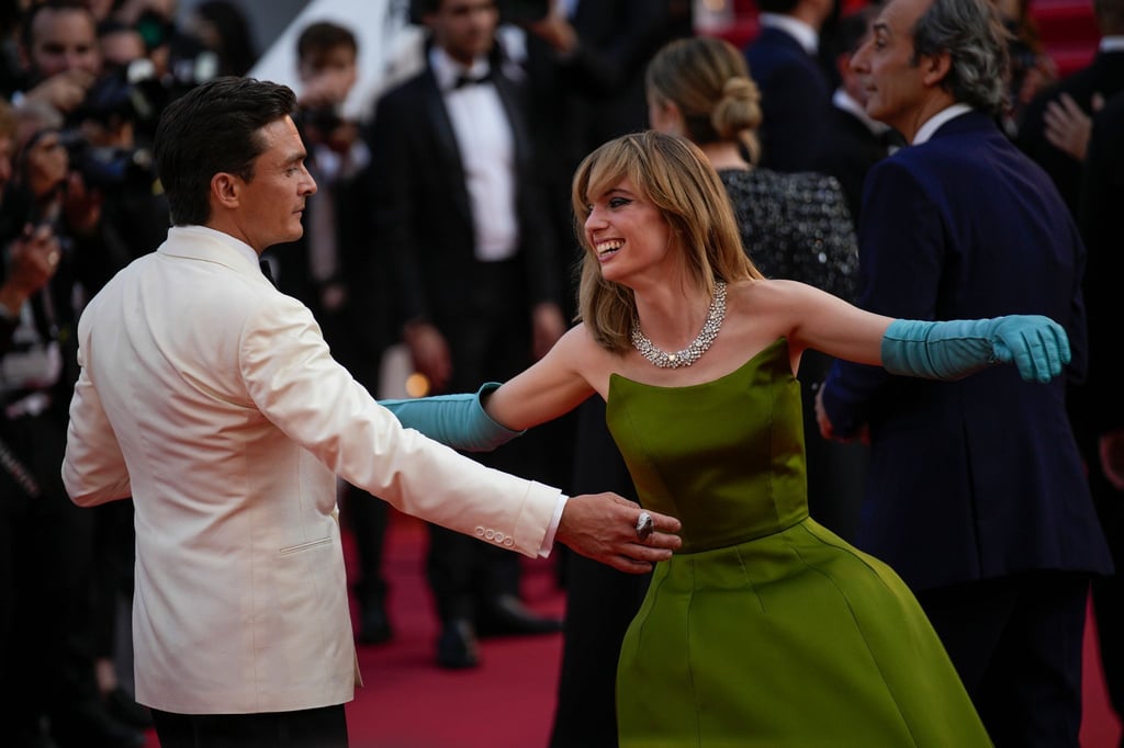 Rupert Friend und Maya Hawke tanzen auf dem roten Teppich.