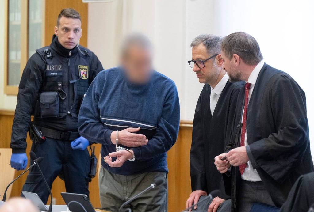 Zum Prozessauftakt wird ein mutmaßliches Mitglied der Terrorgruppe „Vereinte Patrioten“ in den Verhandlungssaal gebracht und unterhält sich mit seinen Verteidigern.