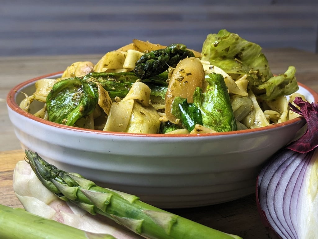 Spargel und Eisbergsalat verpassen der Pasta eine tolle grüne Farbe, Pesto, Zwiebel und Schinkenwürfel die passende Würze.