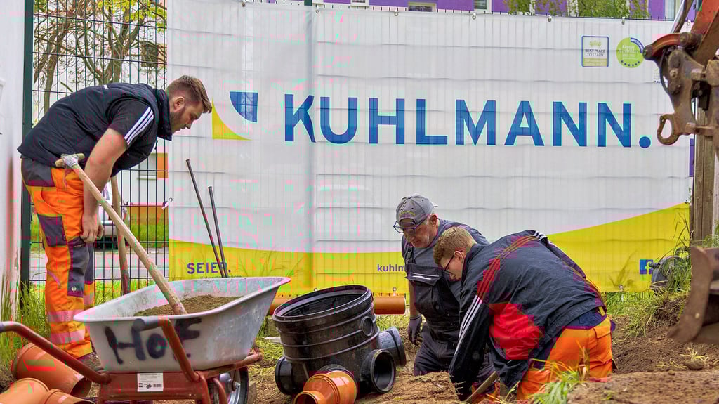 Die Auszubildenden der Firma Kuhlmann installieren den neuen Schmutzwasseranschluss in der Gartenanlage.