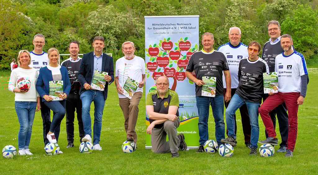 Uli Baumann von der gastgebenden Spielvereinigung Mertendorf (Mitte), Gesundheitsnetzwerkvorsitzender Michael Schwarze (2.v.l.) sowie weitere Initiatoren und Partner der Benefiz-Fußball-Aktion Medien gegen Wirtschaft zugunsten des Projekts „Apfel-Latein“ freuen sich auf das Spiel am 11. August.