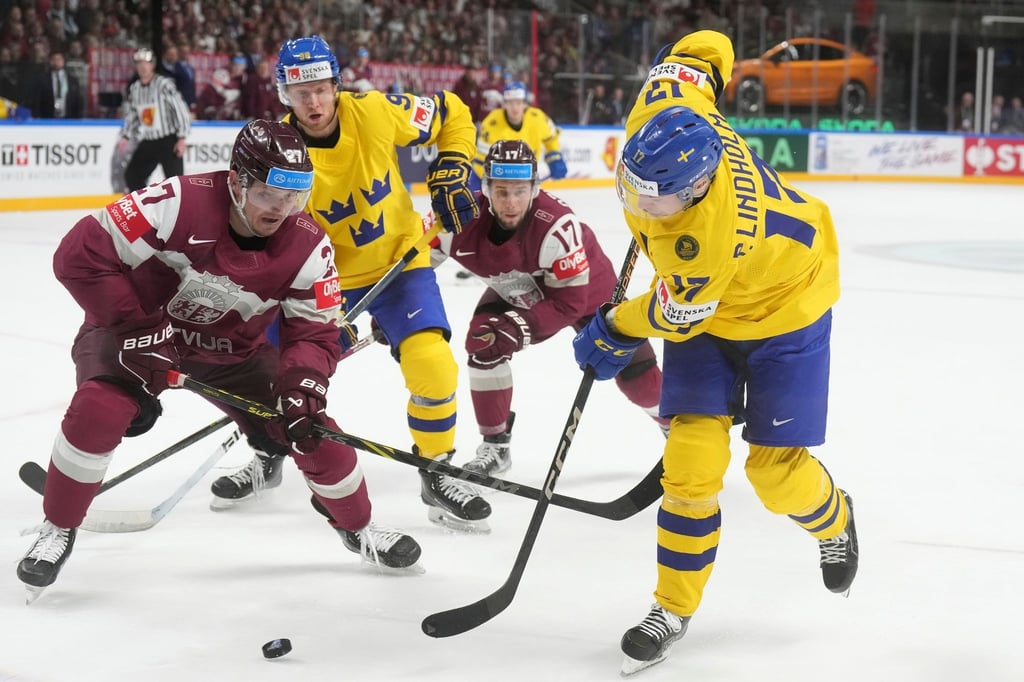 Oskars Cibulskis (l) aus Lettland kämpft mit Pär Lindholm aus Schweden um den Puck.