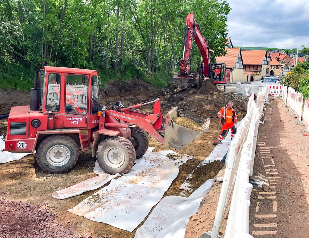 Mitarbeiter der beauftragten Baufirma Kutter HTS sind hier dabei, Drainage für die Entwässerung der neuen Straße zu verlegen.