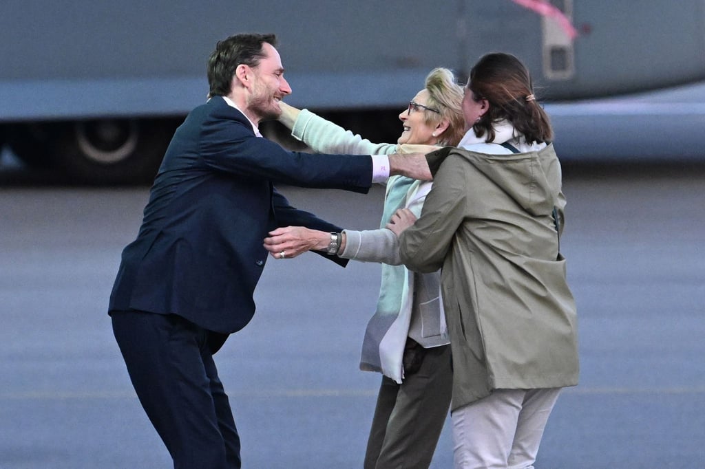 Olivier Vandecasteele (l) trifft seine Familie bei der Ankunft auf dem Militärflughafen Melsbroek.