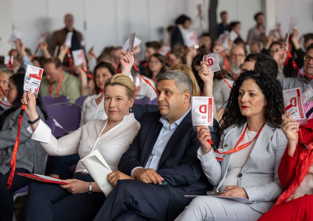 Franziska Giffey (l-r), Raed Saleh und Cansel Kiziltepe halten beim Landesparteitag ihre Stimmkarten hoch.