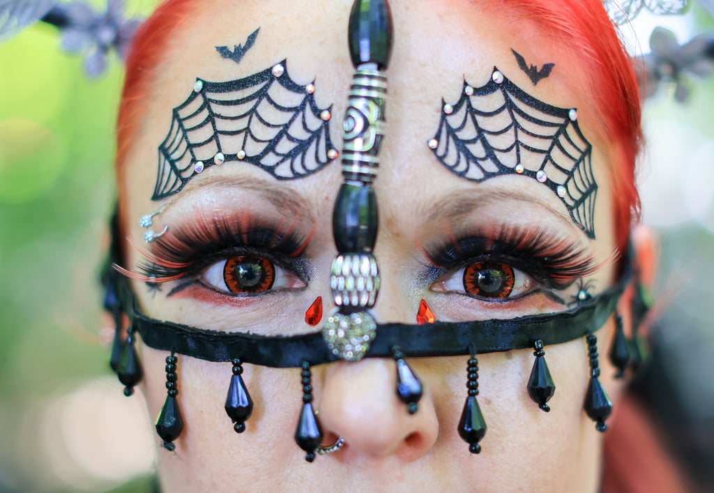 Eine Teilnehmerin mit aufwändigem Gesichtsschmuck besucht das traditionelle Viktorianische Picknick zum Wave-Gotik-Treffen (WGT) im Clara-Zetkin-Park.