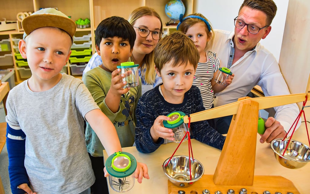 Karl (v.l.), Andres, Liam und Charlotte gehören zu den EinSteins. Gemeinsam mit Erzieherin Lea Röhl und Kita-Leiter Fabian Damerau erforschen die jungen Entdecker im Labor die Spinnen in den Lupengläsern.