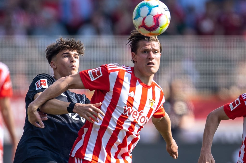 Berlins Kevin Behrens (r) kämpft gegen Noah Weißhaupt von SC Freiburg um den Ball.
