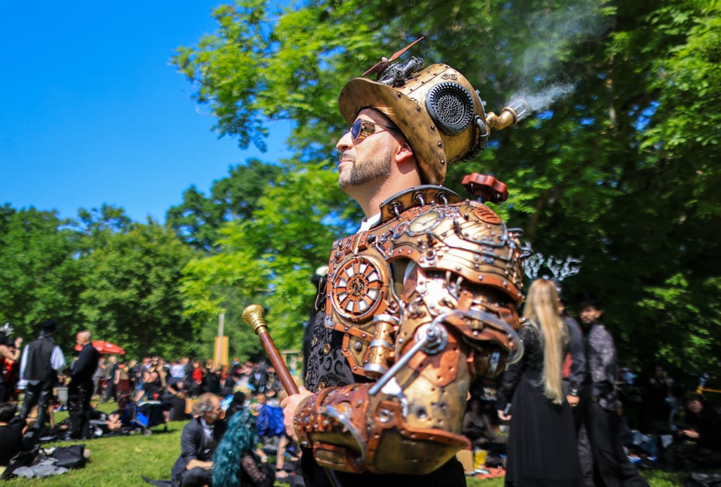 Erich Eisenfaust aus Taucha besucht mit rauchendem Helm das traditionelle Viktorianische Picknick zum Wave-Gotik-Treffen (WGT) im Clara-Zetkin-Park.