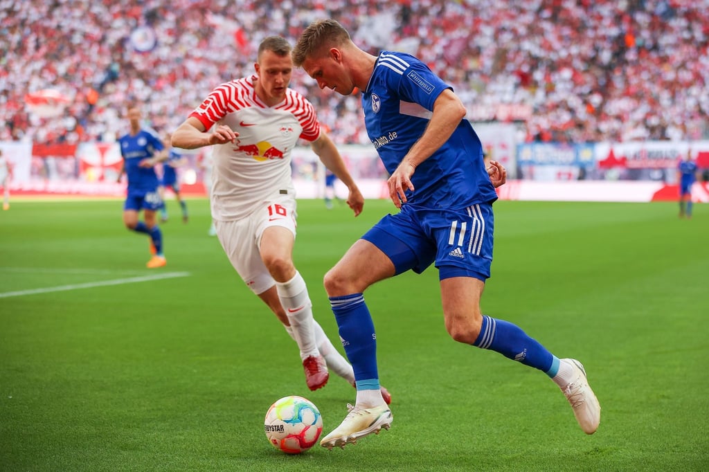 Leipzigs Lukas Klostermann (l) und Schalkes Marius Bülter im Duell.