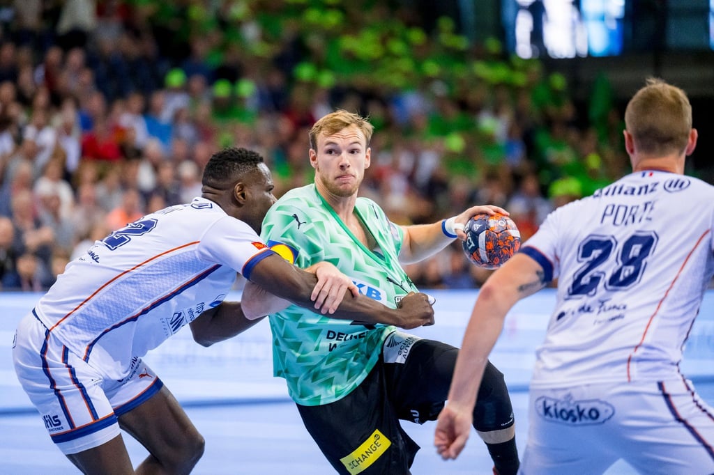 Karl Konan (l) von Montpellier und Mathias Gidsel (M) der Füchse Berlin kämpfen um den Ball.