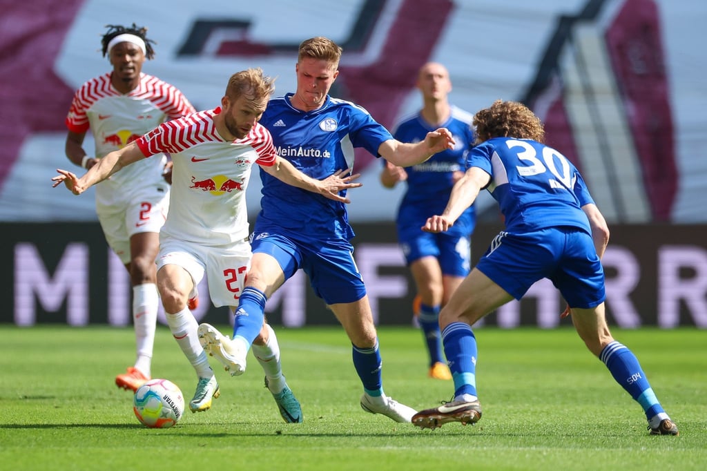 Leipzigs Konrad Laimer (l) im Zweikampf mit Schalkes Marius Bülter.