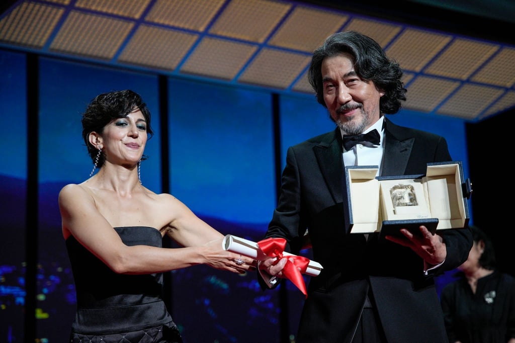Zahra Amir Ebrahimi (l) überreicht Koji Yakusho den Preis als bester Schauspieler für seine Rolle im Film „Perfect Days“ von Regisseur Wenders.