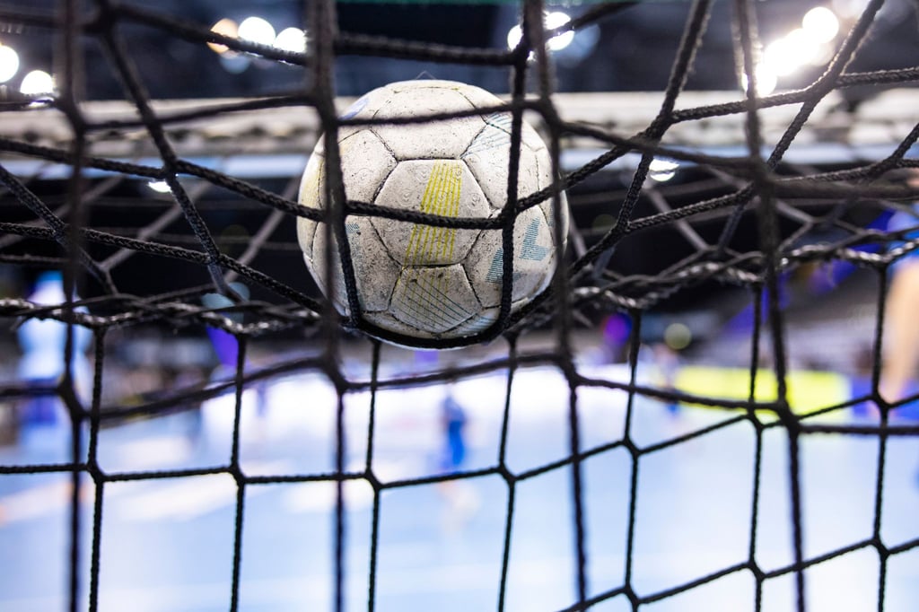 Ein Handball liegt auf einem Tornetz.