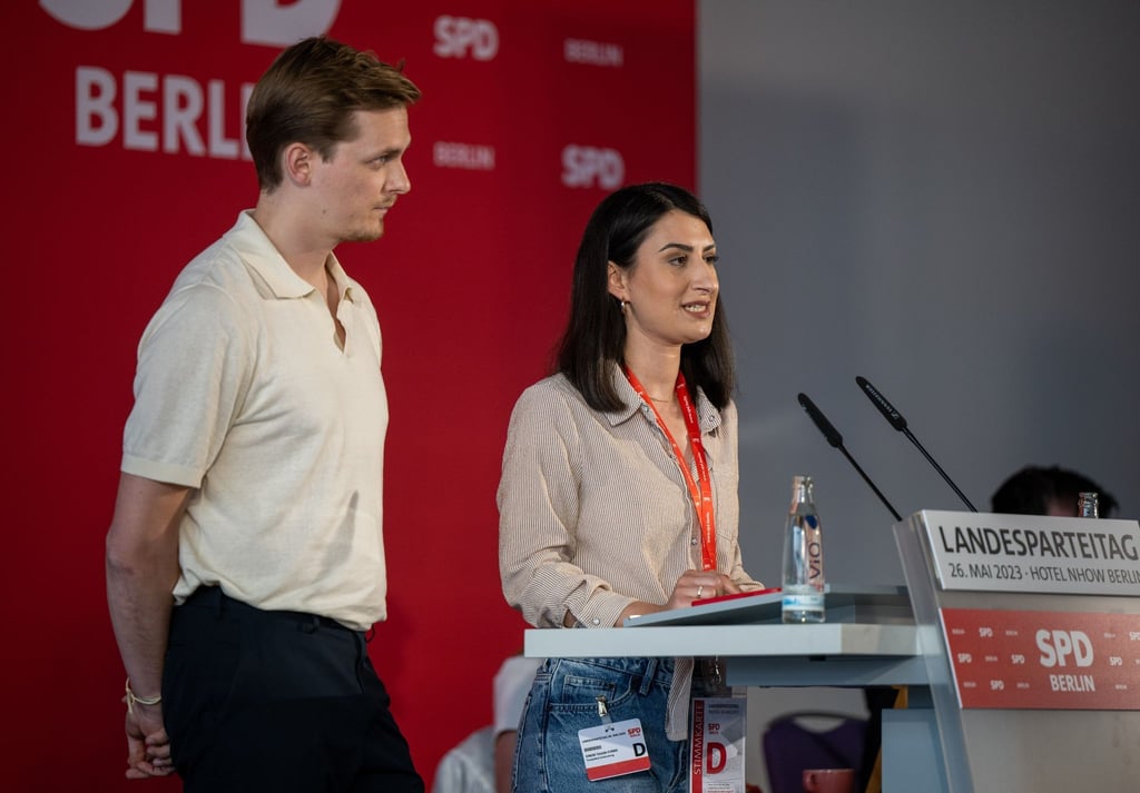 Sinem Tasan-Funke (r) und Peter Maaß stehen beim Landesparteitag auf der Bühne.
