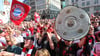 Bayern-Fans jubeln auf dem Marienplatz mit Fahnen, Schals und Meisterschalen.