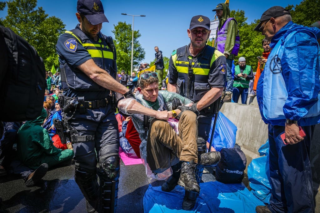 Die Polizei trägt Aktivisten von Extinction Rebellion weg, die die A12 in Den Haag blockieren.