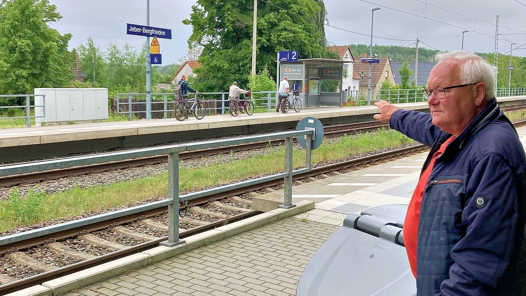 Holger Krauleidis deutet am Bahnhof in Jeber-Bergfrieden auf die nur wenig tiefer liegenden Häuser auf der Jeberner Seite der Gleise.