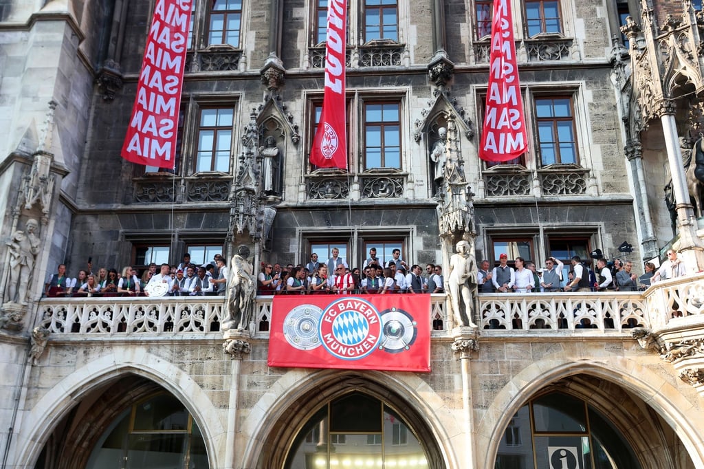 Die Spielerinnen und Spieler des FC Bayern feiern gemeinsam auf dem Rathaus-Balkon.