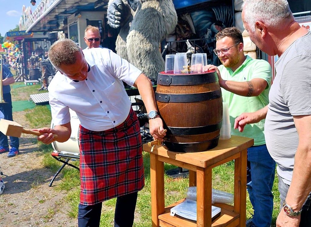 Unter den Blicken von Schausteller-Chef Werner Jacob (rechts) sticht Haldenslebens Bürgermeister Bernhard Hieber ein Bierfass auf der Pfingstmasche an.