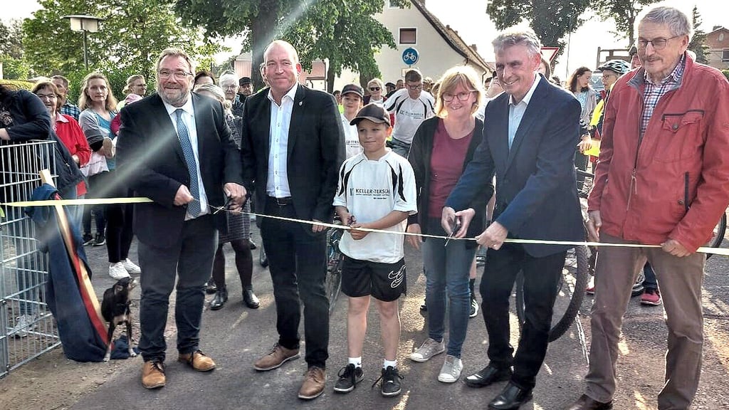 Mica Hering (Mitte) von der Sportjugend schnitt mit Ilka Schüssling, Hans-Werner Kraul (l.), Denis Gruber (2.v.l.), Manfred Behrens (2.v.r.) und Fritz Widdecke das Band zur Radwegfreigabe durch.