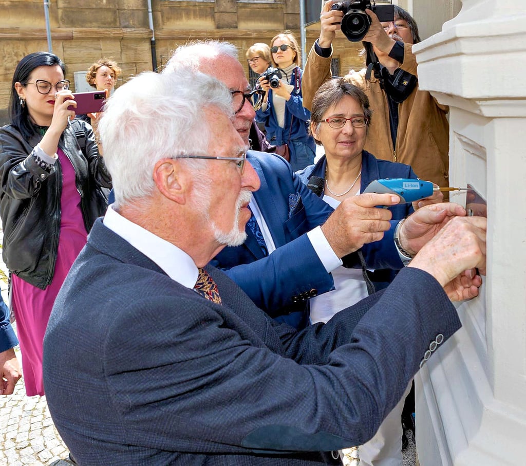 Klaus Wöllner und sein Bruder Peter (dahinter) haben am Freitag die Gedenktfael für ihren Großonkel Arthur Jubelt an dessen ehemaligem Wohnhaus in der Zeitzer Brüderstraße angebracht.