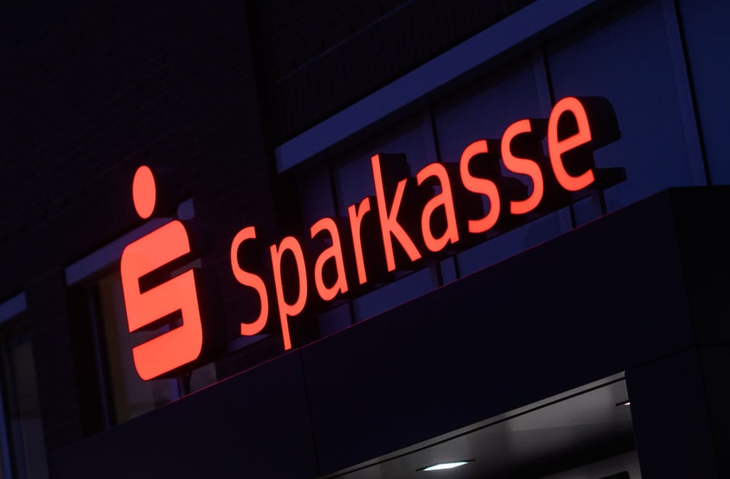 Ein Schriftzug der Sparkasse leuchtet an einer Filiale in der Region Hannover.