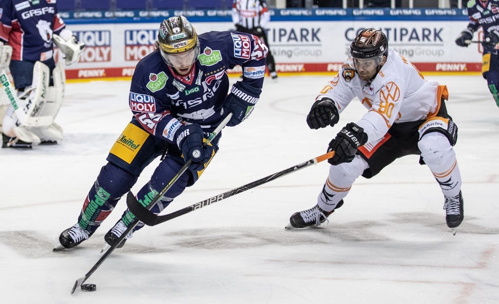 Berlins John Ramage (l) kämpft gegen Jan Nijenhuis von Grizzlys Wolfsburg um den Puck.
