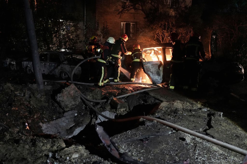 Rettungskräfte löschen in einem geparkten Auto ein Feuer, das nach einem russischen Luftangriff im Kiewer Pecherskyi-Viertel durch herabfallende Trümmer verursacht wurde.