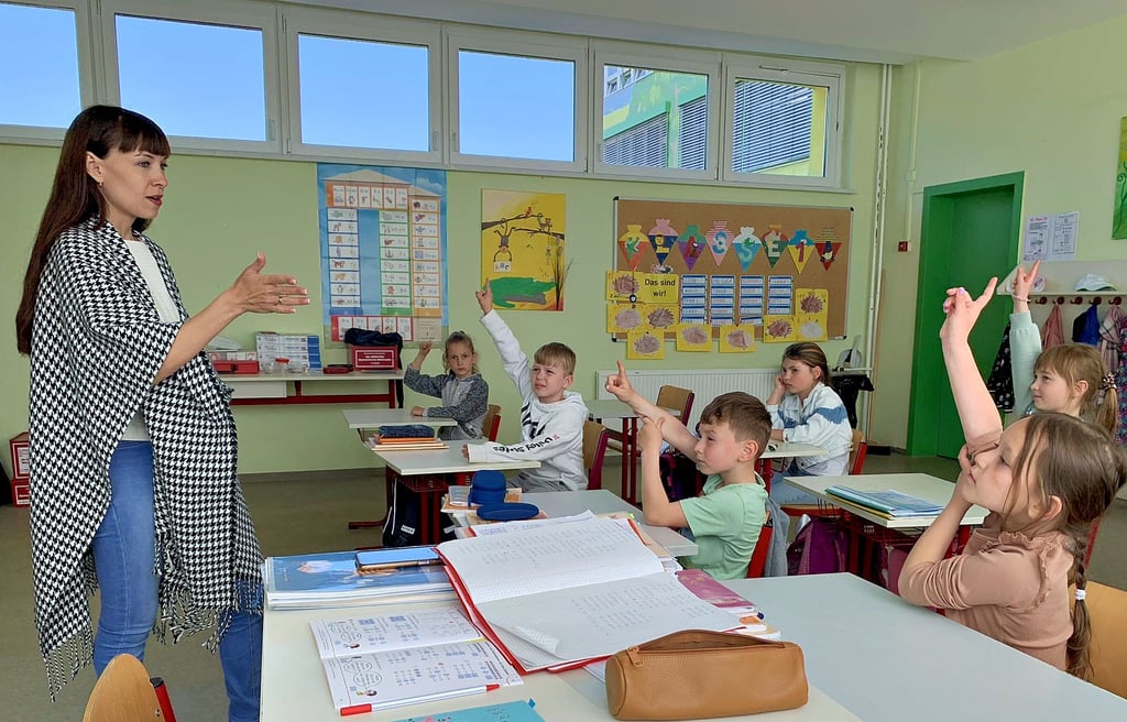 Die pädagogische Mitarbeiterin Nataliya Steblina übt an der Regenbogenschule Kinder der Klasse 1 bis 3 aus der Ukraine deutsche Zahlwörter.