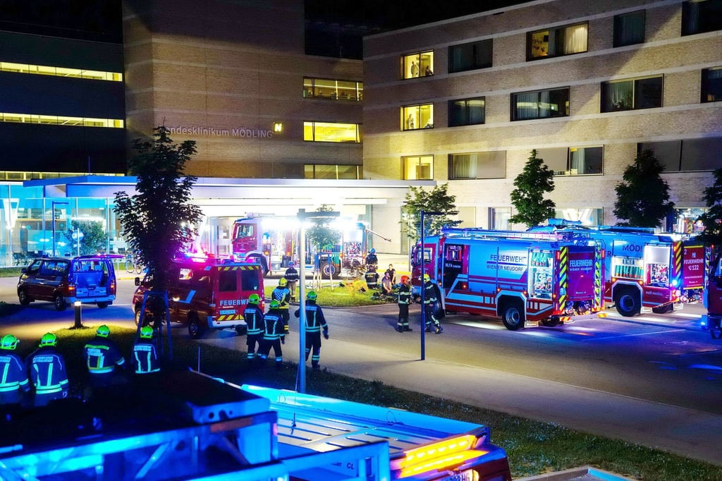 Feuerwehrfahrzeuge und Einsatzkräfte stehen vor dem Klinikum in Mödling.