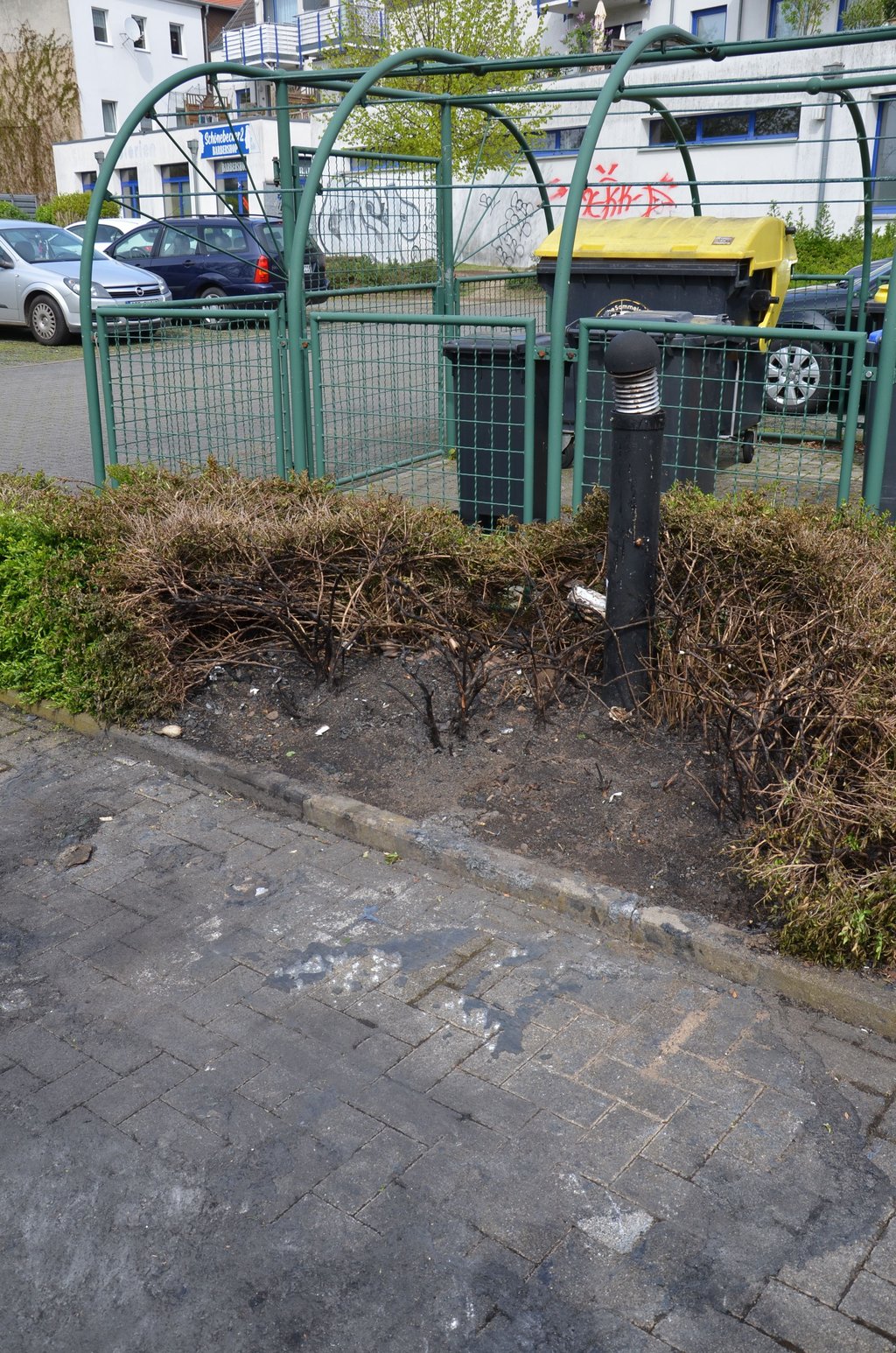 Auch von diesem Container und einer Hecke, die auf einem hinteren Parkplatz in der Steinstraße brannten, sind nur noch Reste auf dem Pflaster übrig.