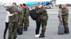 Ehefrauen umarmen auf dem Flughafen von Vilnius ihre Ehemänner, die als Bundeswehrsoldaten in Litauen stationiert sind.