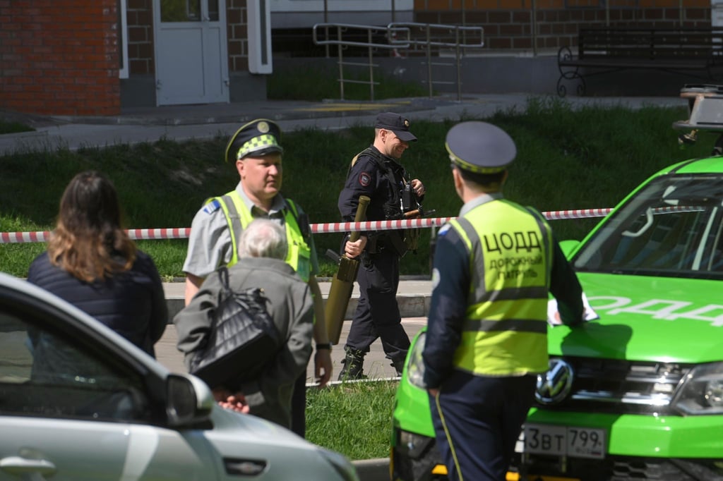 Polizisten bewachen einen Bereich, in dem Berichten zufolge eine ukrainische Drohne ein Wohnhaus beschädigt haben soll.