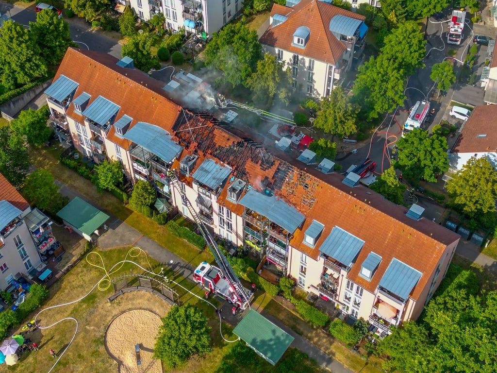 Die Feuerwehr löst einen Brand in einem Mehrfamilienhaus.